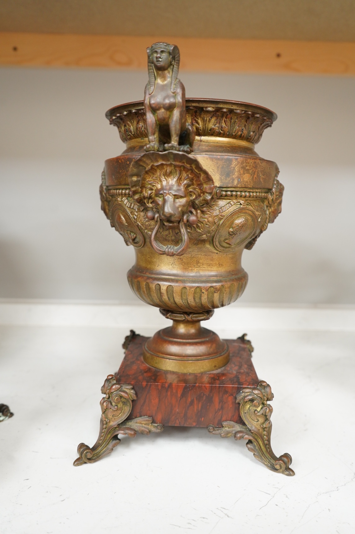 A pair of late 19 century French Egyptian revival bronze and rouge marble urns, 31cm high